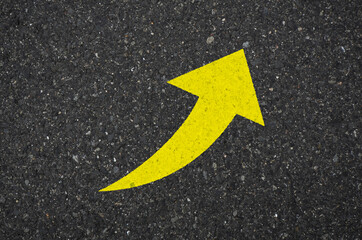 Asphalt with a yellow arrow sign pointing to the upper right. Tarmac road with an arrow pointing to...