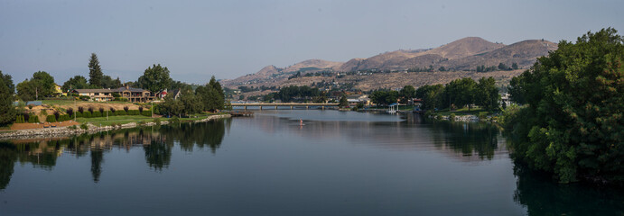 Lake Chelan panoramic landscape on a beautiful summer day, showing the lake, trees and greenery and...