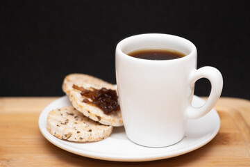 Obraz premium a cup of coffe beside a rice vegan cookies with jelly on the top