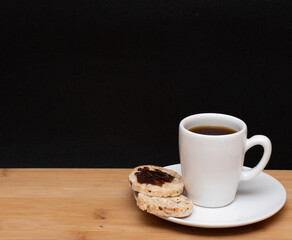 Obraz premium cup of coffe beside a rice vegan cookies with jelly on the top under the wood table
