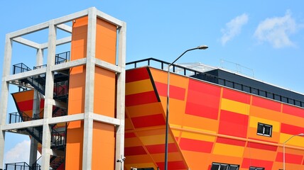 Modern facade of building , steel facade construction. Geometric color elements of the building's facade with planes and lines in red and orange colors.