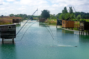 Typical old wooden fishing huts on stils of canal over water. French Atlantic coast. Vendee, France.