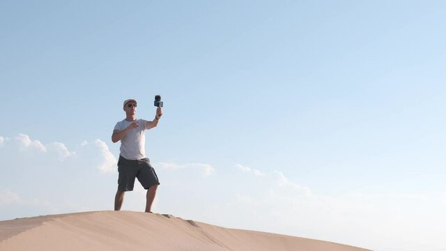 man recording himself with a smart phone at desert, Creating content for his social media