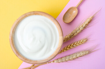 Fototapeta na wymiar Greek yogurt in a wooden bowl and dry barley