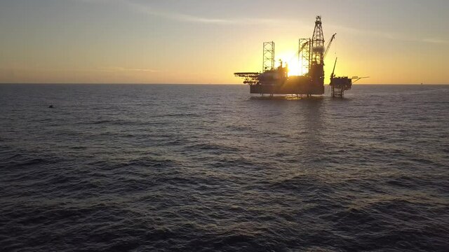 Aerial view of the jack up rig shot during sunset time. Fly around the jack up rig with a drone.
