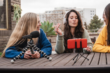 Young diverse people streaming online audio podcast outdoor at home studio - Friends recording with...