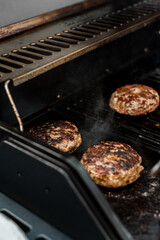 Rindfleisch Burger für Hamburger auf dem Grill mit Käse und Zwiebeln überbacken