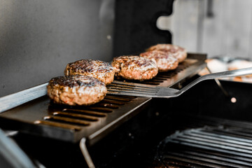 Rindfleisch Burger für Hamburger auf dem Grill mit Käse und Zwiebeln überbacken