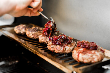 Rindfleisch Burger für Hamburger auf dem Grill mit Käse und Zwiebeln überbacken