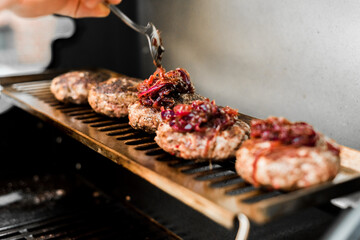 Rindfleisch Burger für Hamburger auf dem Grill mit Käse und Zwiebeln überbacken