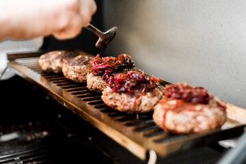 Rindfleisch Burger für Hamburger auf dem Grill mit Käse und Zwiebeln überbacken