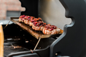 Rindfleisch Burger für Hamburger auf dem Grill mit Käse und Zwiebeln überbacken