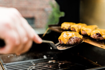 Rindfleisch Burger für Hamburger auf dem Grill mit Käse und Zwiebeln überbacken