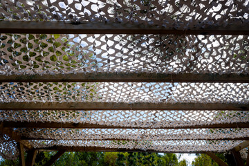 White camouflage military net as a roof to protect from the sun.