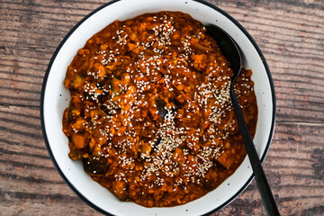vegan eggplant and red lentil curry with sesame seeds topping, healthy plant-based food