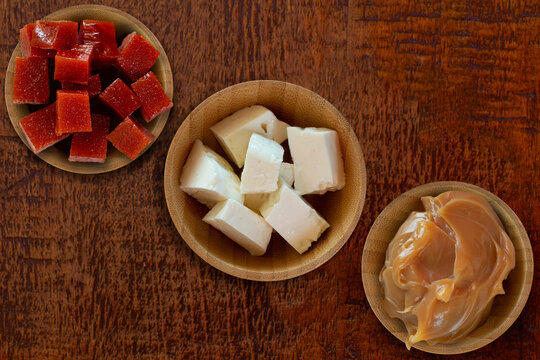 Dulce de leche, guava and white cheese on wooden table - Brazilian desserts. Top view