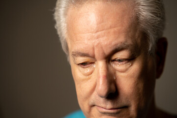 Closeup emotion photo of an old man crying
