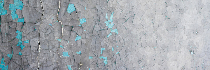 Peeling paint on the wall. Panorama of a concrete wall with old cracked flaking paint. Weathered...