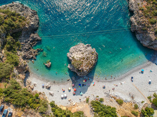 Aerial view of the famous rocky beach Foneas near Kardamyli village in the seaside Messenian Mani area during high tourist Summer period. Messenia, Peloponnese, Greece.