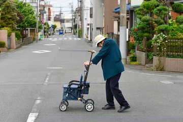 Foto op Canvas 道路を横断する高齢者の女性。An elderly woman crossing the road. © Imagepocket