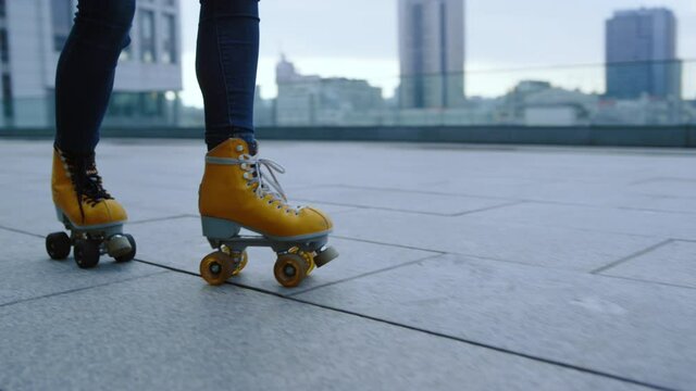 Sporty roller performing skating elements outdoor. Woman riding on rollerblades.