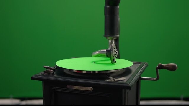 Vintage gramophone . Vintage old gramophone plays a vinyl record on green screen background . Wooden case turntable . Vinyl phonograph . Shot on ARRI ALEXA Cinema Camera in slow motion .
