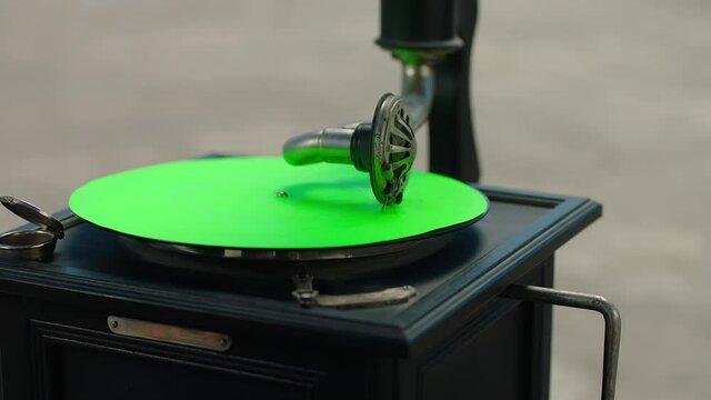 Vintage gramophone . Vintage old gramophone plays a vinyl record on green screen background . Wooden case turntable . Vinyl phonograph . Shot on ARRI ALEXA Cinema Camera in slow motion .