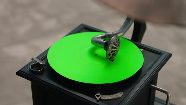Vintage gramophone . Vintage old gramophone plays a vinyl record on green screen background . Wooden case turntable . Vinyl phonograph . Shot on ARRI ALEXA Cinema Camera in slow motion .