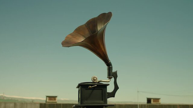 Vintage gramophone . Vintage old gramophone plays a vinyl record on a Sunny day . Outdoor wooden case turntable . Vinyl phonograph . Shot on ARRI ALEXA Cinema Camera in slow motion .