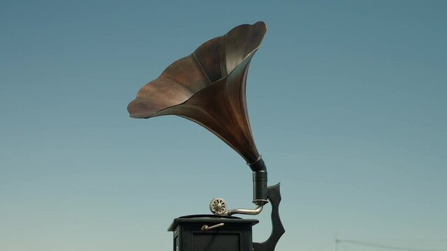 Vintage gramophone . Vintage old gramophone plays a vinyl record on a Sunny day . Outdoor wooden case turntable . Vinyl phonograph . Shot on ARRI ALEXA Cinema Camera in slow motion .