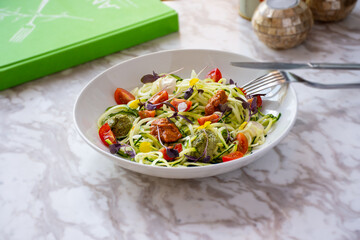 Zucchini noodles served on a plate and with cutlery