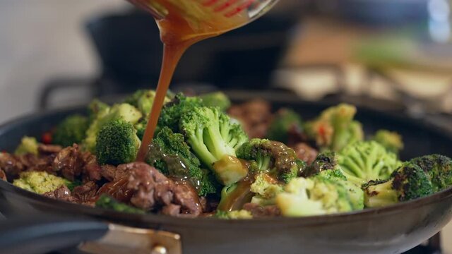 Adding the sauce to the beef and broccoli stir fry meal - slow motion