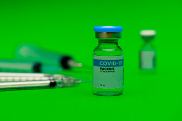Glass capsule of covid-19 vaccine prepared for dose injection by medical syringe as important medication to activate virus immunity to prevent disease outbreak and reduce death.