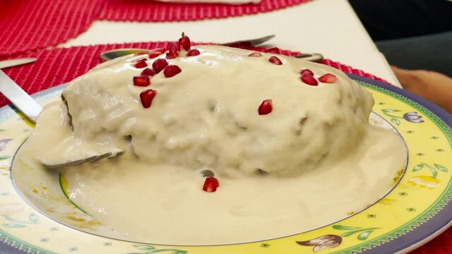 Pomegranate seeds falling over traditional mexican wood "Chile en Nogada"