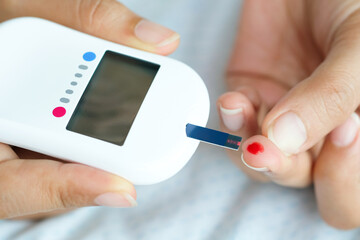 hand of people check diabetes and high blood glucose monitor with digital pressure gauge. Healthcare and Medical concept