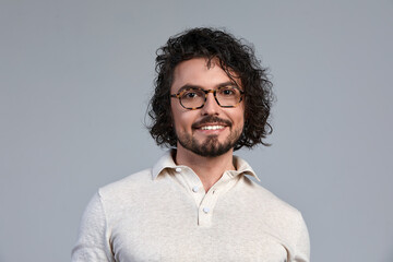 Obraz premium Middle-aged man, stylishly dressed in a gray T-shirt and glasses, business style, smart kezhl, handsome business man with glasses, business style concept, modern approach to men's fashion.