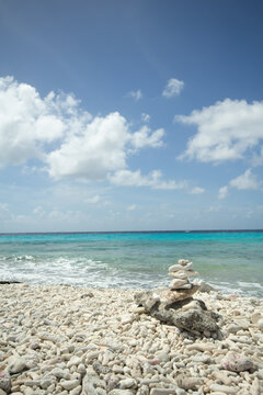 Coral Beach in Bonaire with stacked stones and a peaceful view of the ocean. 