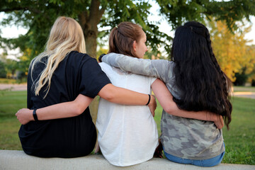Friendship, girls sitting, arms around each other