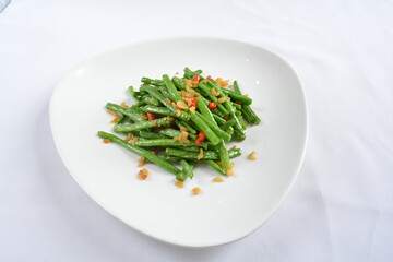 stir fried long green bean vegetables with dried shrimp in soy sauce in white background asian halal menu