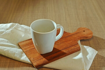 White empty cup on wooden board