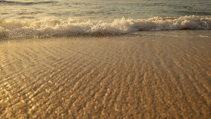 Scenic seascape. Milky foam waves at the beach. Sunset time. Waterscape for background. Selected soft art focus. Sunlight reflection on the water and sand. Balangan beach, Bali, Indonesia