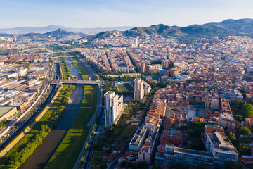 Fototapeta premium Aerial urban landscape of Santa Coloma de Gramenet municipality and Besos river, Catalonia, Spain