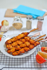 Fried fish on wooden skewers with sauce