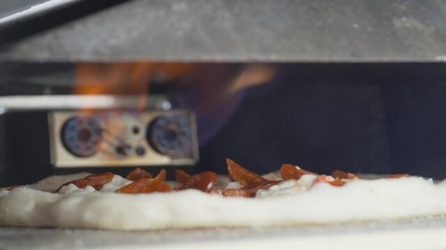 A Pizza baking in a gas-powered oven - close up static shot
