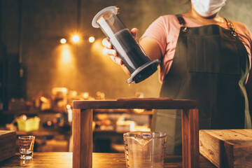 professional barista make a fresh drink with tea and milk on cup, beverage tasty bar cafe, hand holding milk latte in coffee shop or food restaurant, bartender working in cafeteria uniform