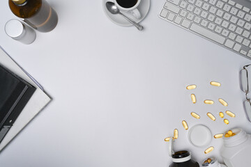Modern workspace with coffee cup, notebook and fish oil capsules on white table.