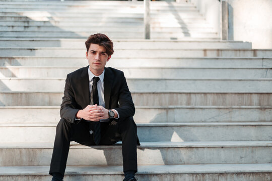 young man in casual suit sitting on a stairs place