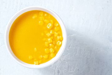 Sweet corn cream soup, shot from above with a place for text. Vegan maize chowder, healthy food