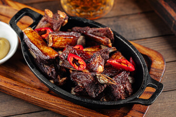 Roast lamb ribs with pepper and mustard on a wooden background