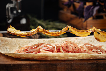 Caucasian grilled potato shashlik skewers on a wooden background